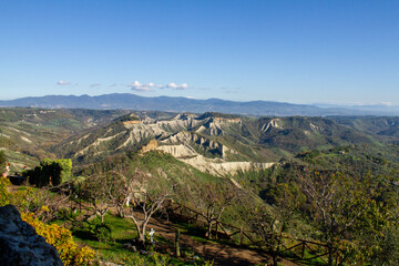 Fototapeta na wymiar Remote view of the valley of the badlands, formed by landslides and by the erosion of the tufa, lava and clayey rock.Civita di Bagnoregio,Italy.