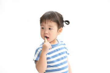 A cute little  Asian girl brushing her teeth isolated on white background. Healthy teeth concept.