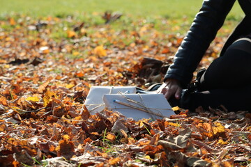 Wrapped notebooks and pencil as presents in the autumn leafs