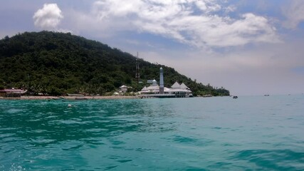 Floating mosque, religious building on the blue ocean in Malaysia, Perhentian Island. Popular travel destination, boat view.