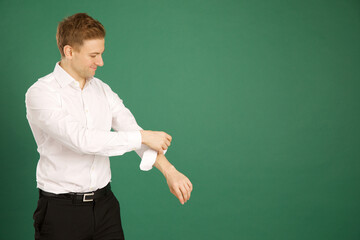 Attractive caucasian adult male wearing white suit and rolling up sleeves