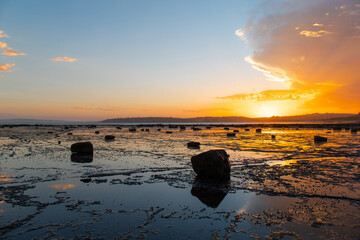 Fototapeta na wymiar Silhouette of rocks on the beach reef at sunset time.