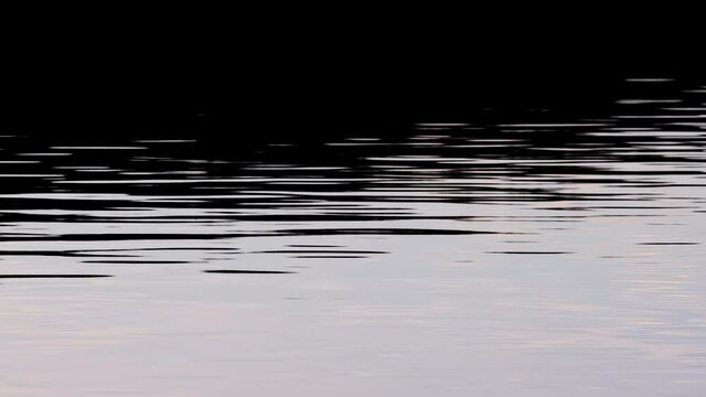 light reflecktions on dark water surface
