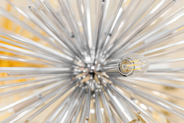 Close-up of a switched off incandescent lamp in a ceiling with a clear glass chandelier in the form...