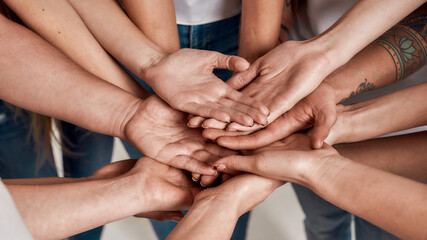 Diverse women holding their hands open palm on top of each other like a team. Concept of support, racial unity and relations in society