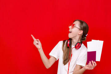 Beautiful teen Girl With Passport And Flight Tickets, on red background.Copy space.