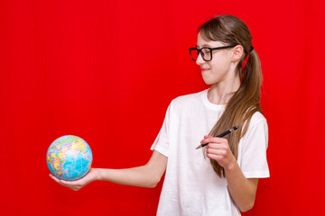 Close up side view teenager girl hold earth globe eyewear pen red studio background