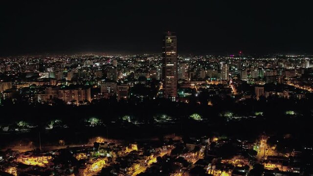 City of Santo Domingo illuminated on a clear night, with a view of a large building shot with drone