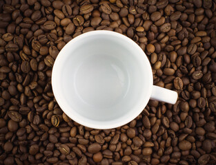 White Cup and scattered roasted coffee beans