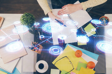 Social network theme hologram over hands taking notes background. Concept of global international people connect. Double exposure