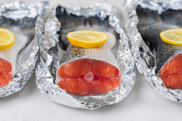 Fresh raw salmon fillet tail part with lemon on a light background. Pescatarian food menu, recipe....