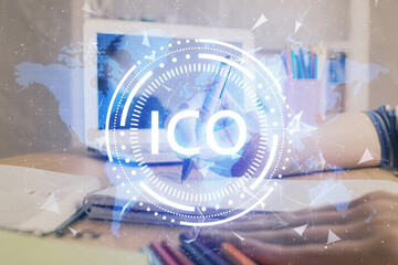 Cryptocurrency hologram, bitcoin, ico theme over hands taking notes background. Concept of...