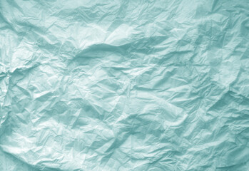 Crumpled cyan toned paper sheet surface.