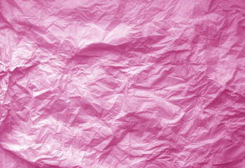 Crumpled pink paper sheet surface.