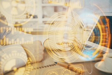 Technology theme hologram with man working on computer on background. High tech concept. Double exposure.