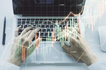 Double exposure of abstract creative financial diagram with hand typing on computer keyboard on background, banking and accounting concept