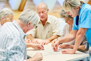 Gruppe Senioren mit Puzzle im Seniorenheim beim Spielen