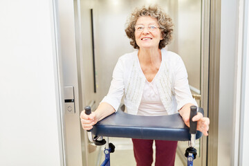Seniorin mit Rollator im Fahrstuhl