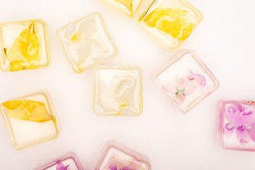 top view of transparent fruit and vegetable ice cubes on white 