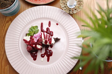 Chocolate cake with whipped cream and raspberry sauce.
Culinary photography. Food styling.