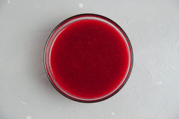 Viburnum jam in glass bowl on the light grey concrete surface. Minimalistic concept