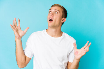 Young caucasian handsome man screaming to the sky, looking up, frustrated.