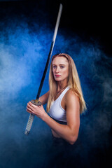 Portrait of beautiful sportswoman woman with katana in studio