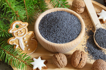 Poppy seeds in a wooden bowl surrounded by Christmas decorations