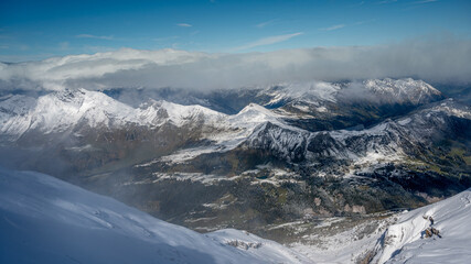 Winter landscape of snow covered mountains and green valley in fog. Glaciers 3000, Diablerets in Switzerland.