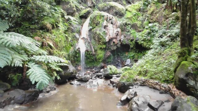 Aerial approaching charming cascade. Water stream. Sao Miguel Island , Azores