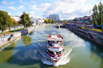 Ausflugsbootfahrt auf dem Donaukanal im Herbst, beste Zeit zum Entspannen, im Hintergrund Innenstadt von Wien