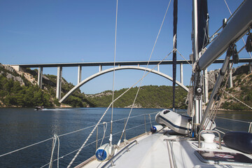 Fototapeta premium Sail boat under the bridge