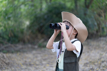 An adventure boy is using a binocular.