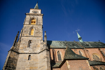 Fototapeta na wymiar Medieval catholic church of Saint Jilji with gothic High clock tower in sunny autumn day, Nymburk, Central Bohemia, Czech Republic