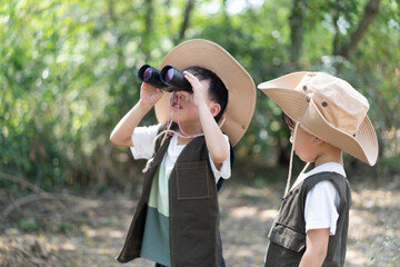 Adventure boys are using a binocular.