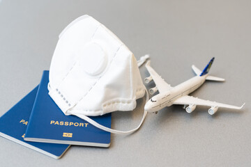 travel during the covid-19 pandemic. airplane model with face mask and travel documents