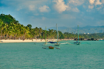 White beach of Boracay island. Tourists walk along the beach and swim in the sea. A few days before the outbreak of the coronavirus.