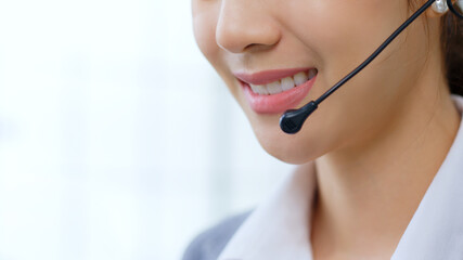 Closeup Asian woman call center, customer service, telesales in formal suit wearing headset or...