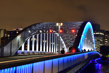 青く光る隅田川に架かる永代橋