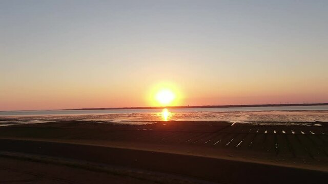 Stunning Orange Sunset Over Dike And Tidal Flat Of North Sea In Germany Near Husum