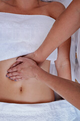 Fototapeta na wymiar Young woman having massage on her abdominal at spa salon..Top view.