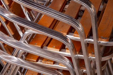 Fototapeta premium Close Up of metal wooden chairs stacked in a pile. Abstraction.