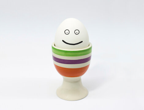 Smiling egg in eggcup holder isolated on white background