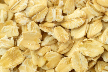 Raw oat flakes or oatmeal background texture macro close-up