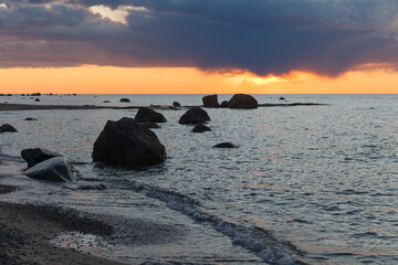 Fototapeta na wymiar Beautiful shoreline with stones at the sunset