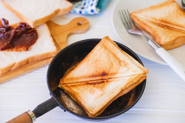 Roasted toast bread popping up of stainless steel toaster in home kitchen