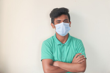 A young man with protective mask against a wall 