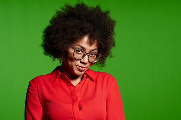 Fototapeta na wymiar Shy young African-American girl in glasses and red shirt looking at camera