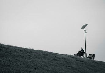 Lonely senior man sitting on a bench. Black and white photo.