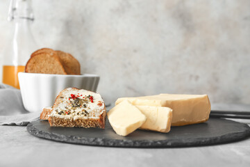 Fresh butter and slices of bread on dark board
